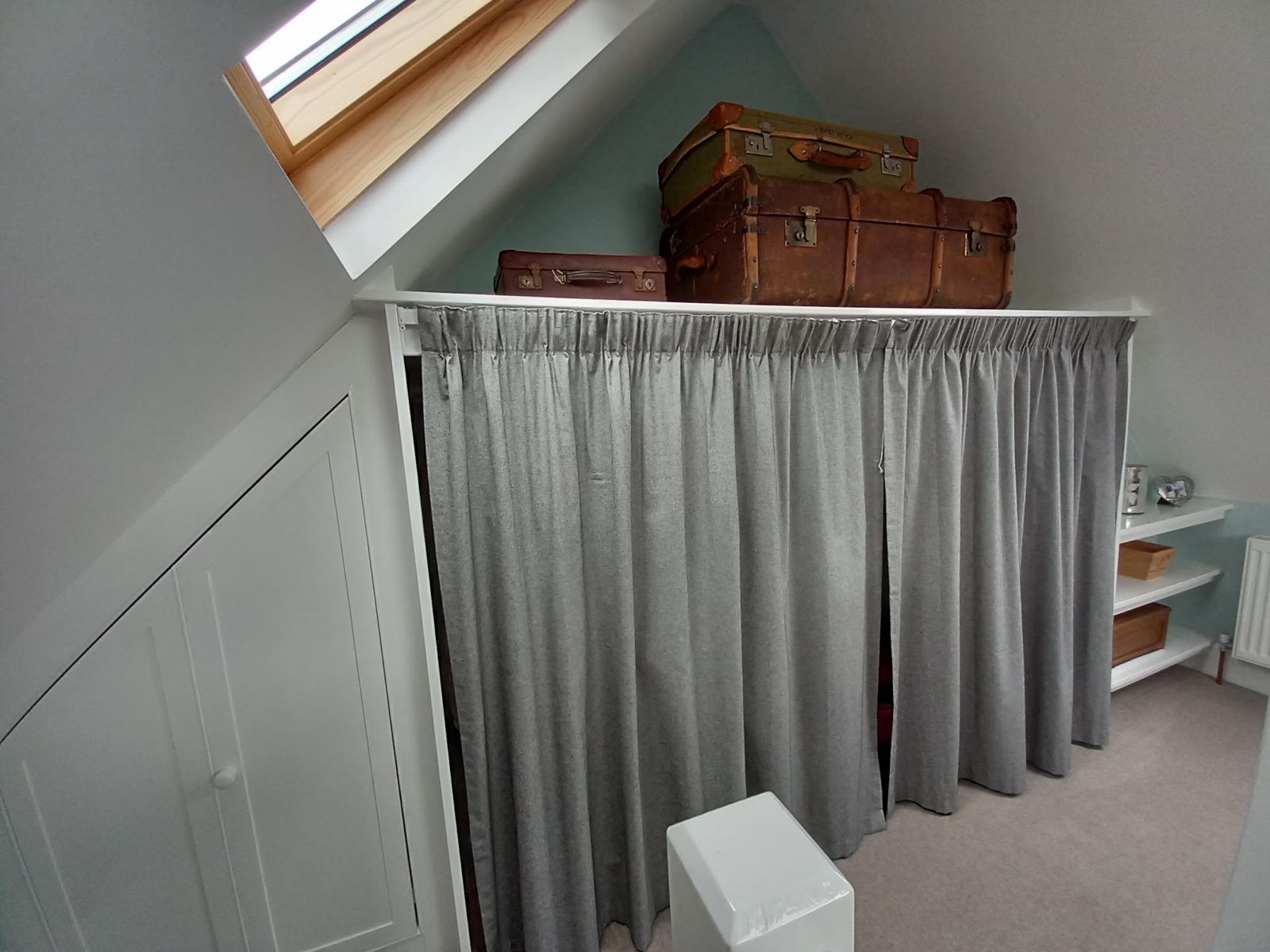 Loft-room storage under the eaves with a curtain front and cupboards