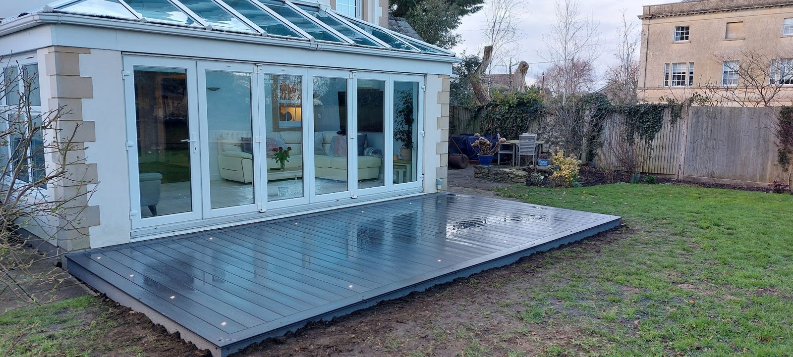 Grey composite decking laid in front of a garden room with bifold doors